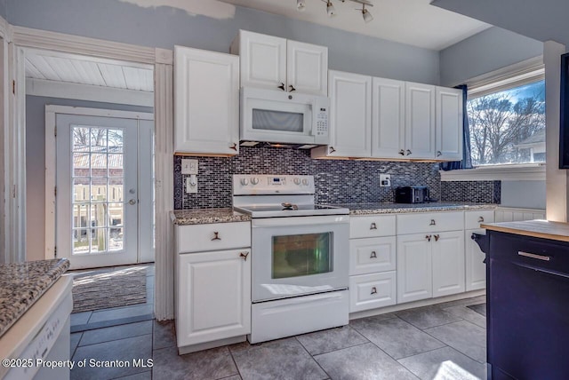 kitchen featuring decorative backsplash, white appliances, and white cabinets