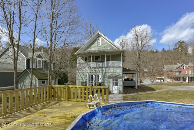 view of swimming pool with french doors and a wooden deck