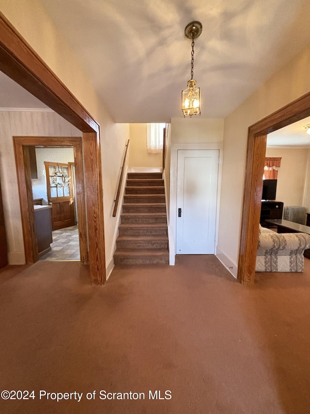 staircase with a notable chandelier and carpet floors