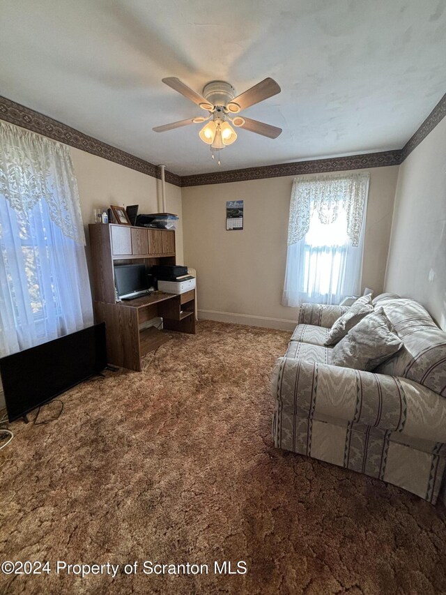 carpeted living room with ceiling fan