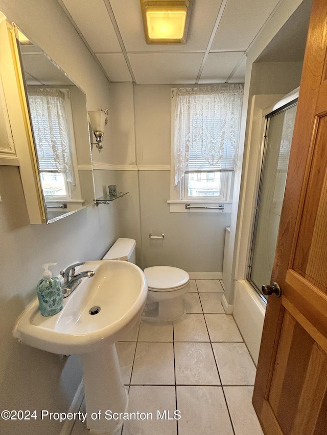 bathroom with toilet, tile patterned floors, and enclosed tub / shower combo