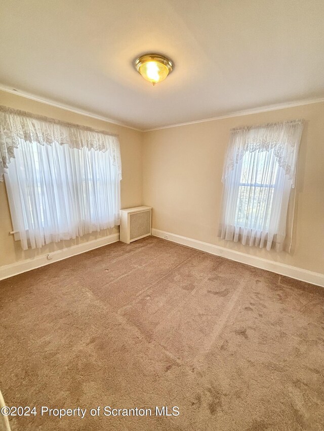 unfurnished room featuring carpet flooring and radiator