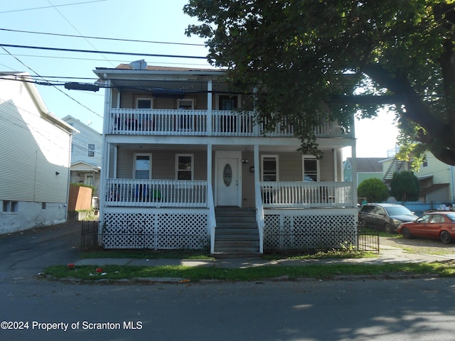 view of front of home with covered porch and a balcony