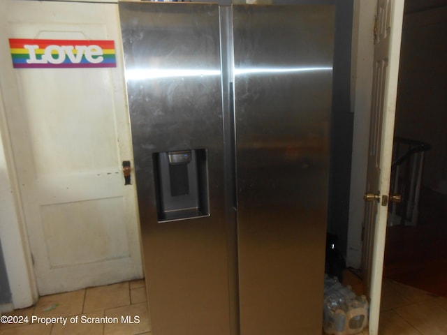 interior space with stainless steel fridge and light tile patterned flooring