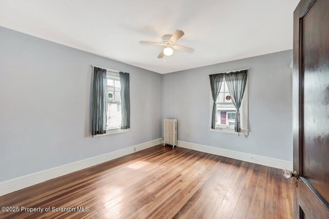908 Prescott Ave, Scranton, PA 18510 - unfurnished room with radiator, a ceiling fan, and wood-type flooring