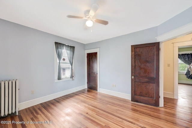 908 Prescott Ave, Scranton, PA 18510 - unfurnished bedroom with radiator heating unit, wood finished floors, and a ceiling fan