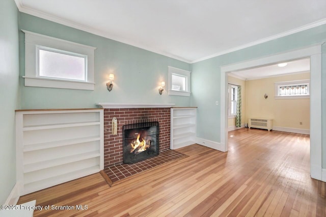 908 Prescott Ave, Scranton, PA 18510 - unfurnished living room featuring radiator heating unit, hardwood / wood-style floors, a brick fireplace, and crown molding