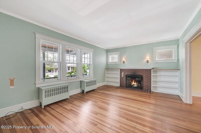 908 Prescott Ave, Scranton, PA 18510 - unfurnished living room featuring radiator, light wood-style flooring, ornamental molding, and a brick fireplace