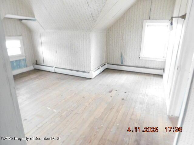bonus room with vaulted ceiling and hardwood / wood-style flooring