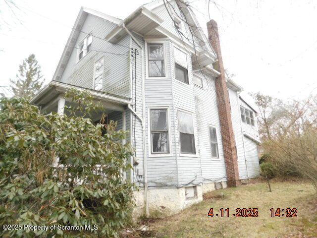 view of side of home featuring a chimney