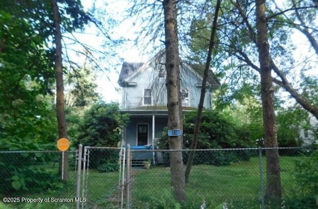 view of front of home with covered porch, fence private yard, and a front yard