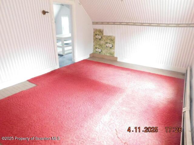 additional living space with carpet and vaulted ceiling