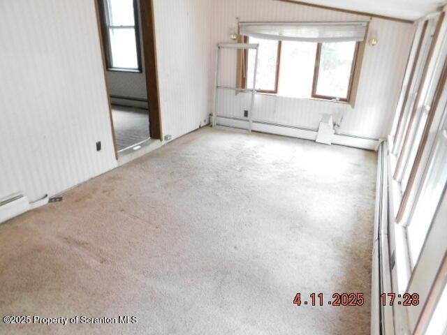 empty room featuring a baseboard radiator, a baseboard heating unit, and a healthy amount of sunlight