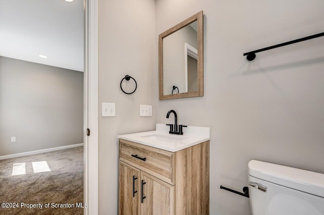 bathroom with toilet, baseboards, and vanity