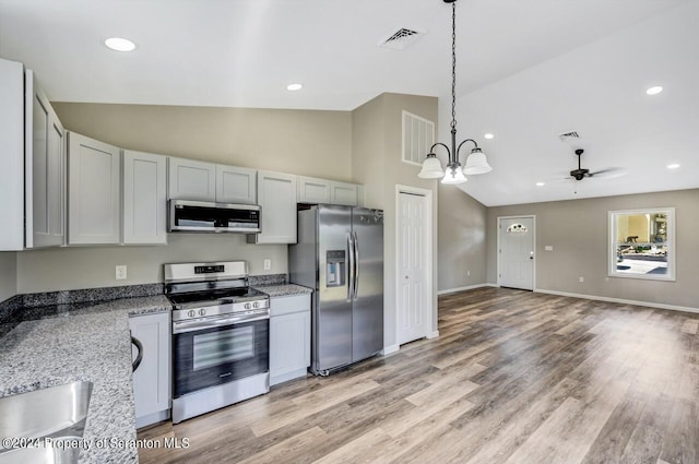 kitchen featuring visible vents, light stone counters, decorative light fixtures, stainless steel appliances, and light wood-type flooring