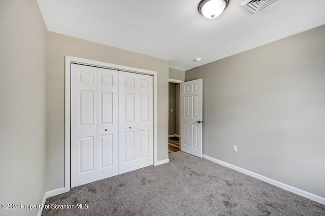 unfurnished bedroom with carpet, a closet, visible vents, and baseboards