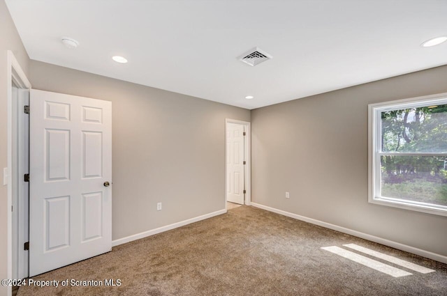 carpeted spare room with recessed lighting, visible vents, and baseboards