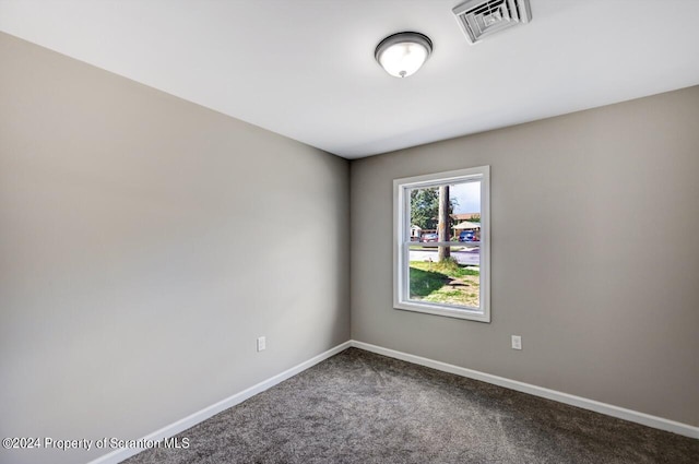 carpeted spare room featuring visible vents and baseboards