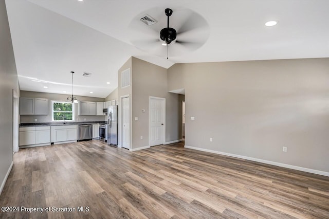 unfurnished living room with lofted ceiling, light wood finished floors, visible vents, and a ceiling fan