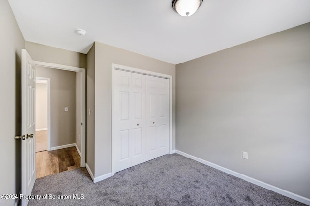 unfurnished bedroom featuring carpet, a closet, and baseboards