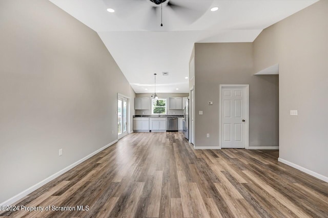 unfurnished living room with ceiling fan, high vaulted ceiling, recessed lighting, wood finished floors, and baseboards