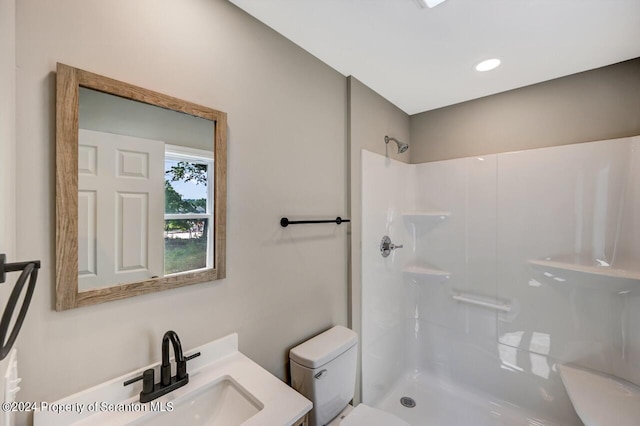 full bath featuring a shower, vanity, and toilet