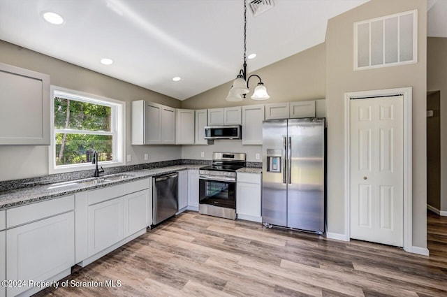 kitchen featuring appliances with stainless steel finishes, pendant lighting, visible vents, and a sink