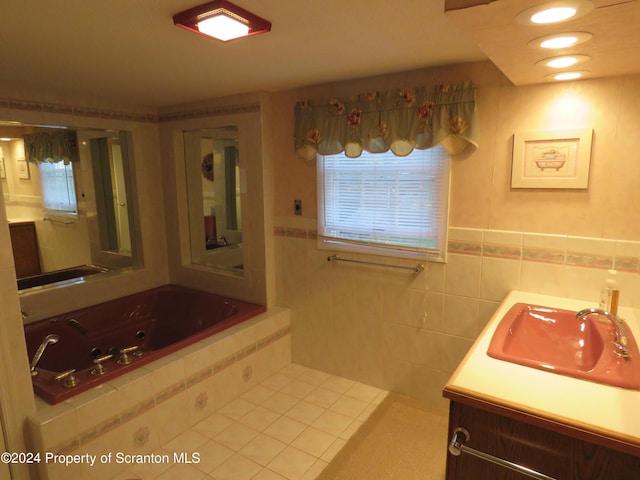 bathroom with tiled bath, tile patterned flooring, vanity, and tile walls