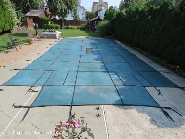 view of pool featuring a patio area and a yard