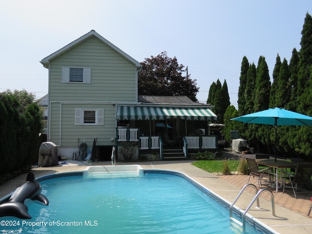 view of pool featuring a patio area and a wooden deck