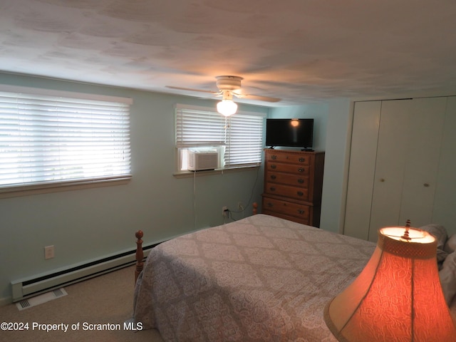 bedroom with cooling unit, ceiling fan, a baseboard radiator, multiple windows, and a closet