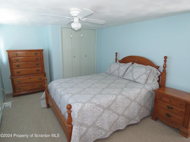 bedroom with ceiling fan, a closet, and light carpet