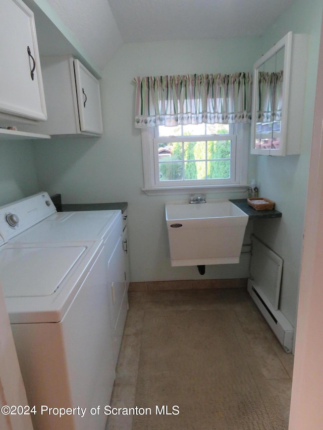 clothes washing area with cabinets, baseboard heating, washer and dryer, and sink