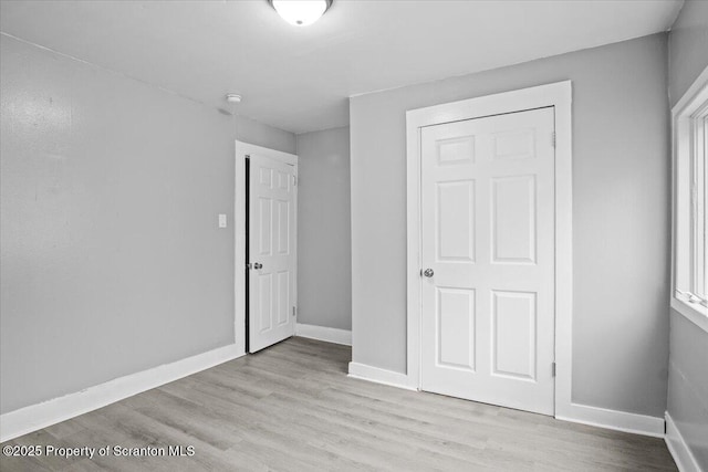 unfurnished bedroom featuring baseboards and wood finished floors