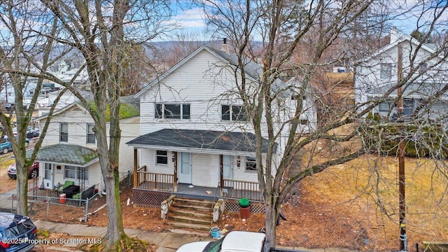 view of front of home with a porch, fence, and a chimney