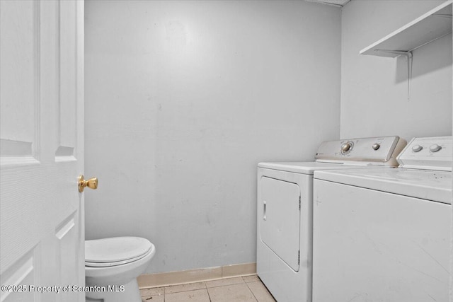 laundry area featuring laundry area, baseboards, washing machine and clothes dryer, and light tile patterned floors