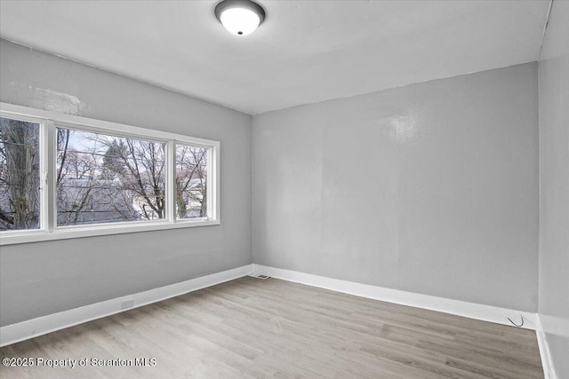 unfurnished room featuring wood finished floors and baseboards