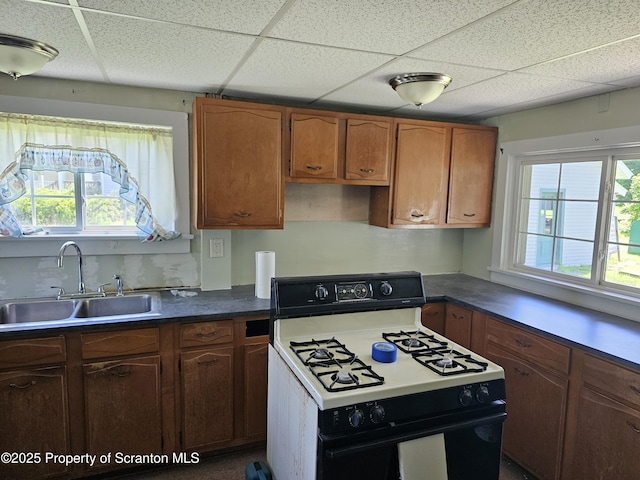 464 Main St, New Milford, PA 18834 - kitchen featuring range with gas stovetop, a paneled ceiling, plenty of natural light, and brown cabinets