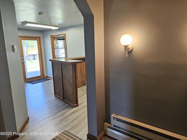 464 Main St, New Milford, PA 18834 - hallway with a baseboard heating unit, light wood finished floors, and arched walkways