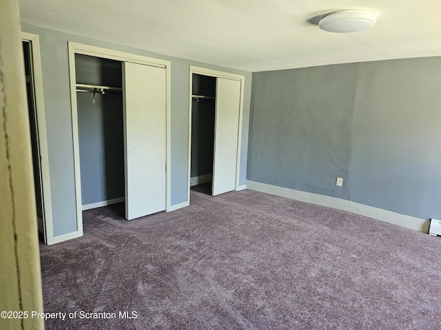 464 Main St, New Milford, PA 18834 - unfurnished bedroom featuring two closets and dark carpet