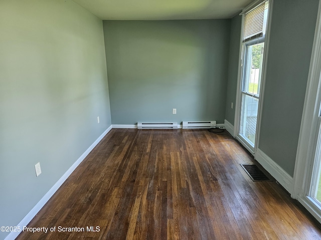 464 Main St, New Milford, PA 18834 - empty room featuring a baseboard heating unit, dark wood finished floors, and plenty of natural light