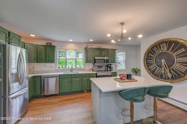 523 Hudson St, Forest City, PA 18421 - kitchen with appliances with stainless steel finishes, green cabinetry, light wood finished floors, light countertops, and a kitchen bar