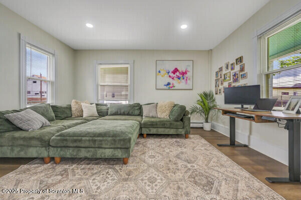 523 Hudson St, Forest City, PA 18421 - living area with wood finished floors, recessed lighting, a baseboard heating unit, and a desk