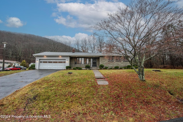 ranch-style house with a garage and a front lawn