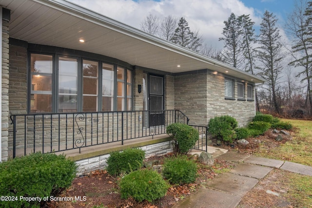 view of exterior entry featuring covered porch