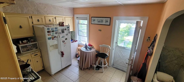 525 N Irving Ave, Scranton, PA 18510 - kitchen featuring white fridge with ice dispenser, arched walkways, healthy amount of natural light, light tile patterned flooring, and a drop ceiling