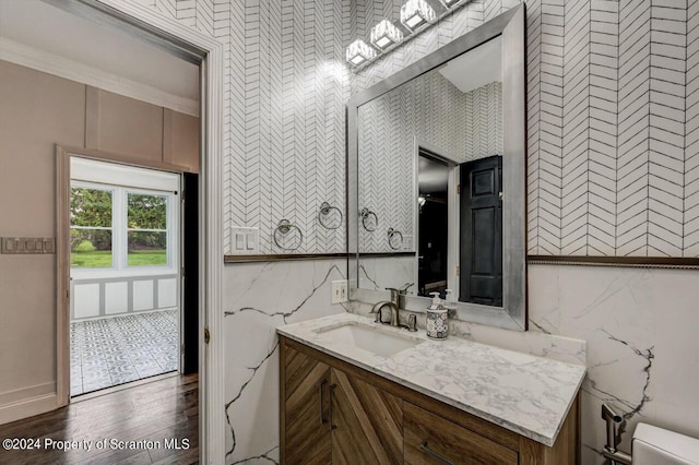 bathroom with hardwood / wood-style floors, vanity, and ornamental molding