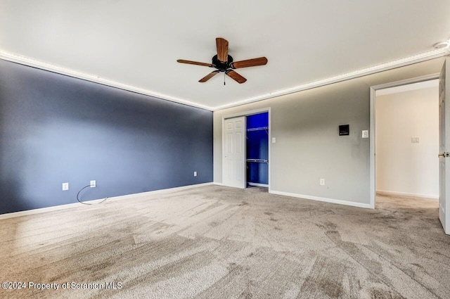 empty room with carpet flooring, ceiling fan, and crown molding