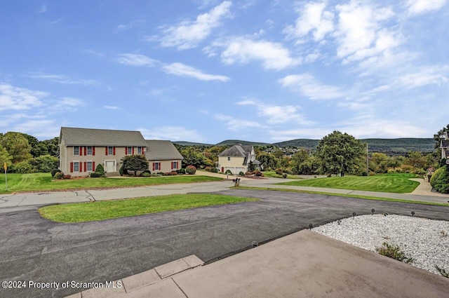 exterior space with a mountain view and a front yard