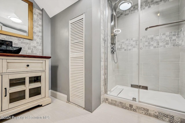 bathroom with tile patterned floors, vaulted ceiling, and walk in shower